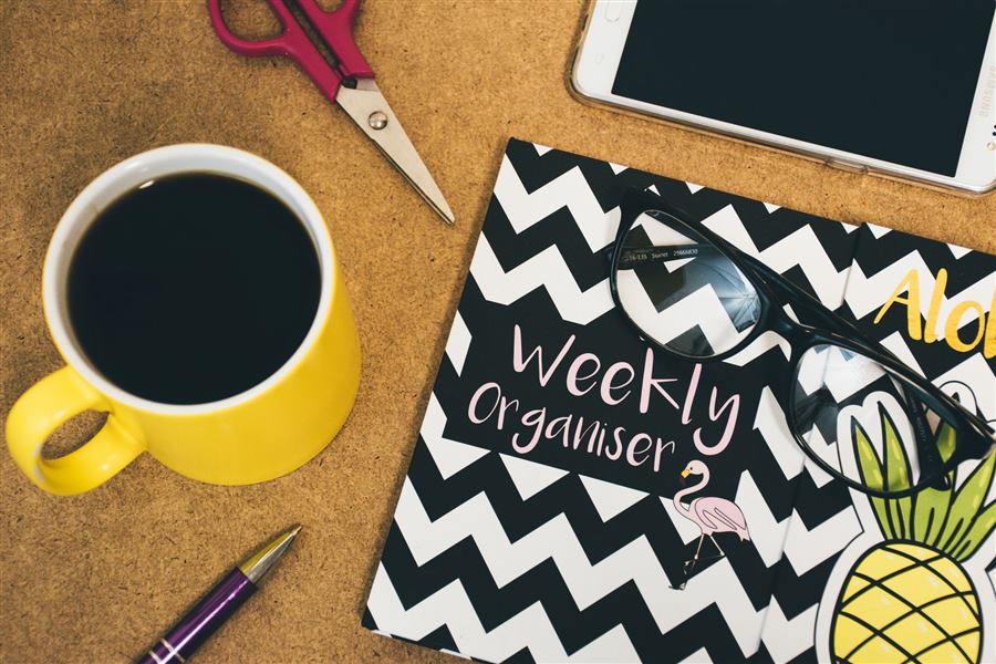 Flat lay of a workspace with coffee, notebook, smartphone, scissors, and pen for creativit